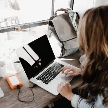 Woman from behind working on laptop