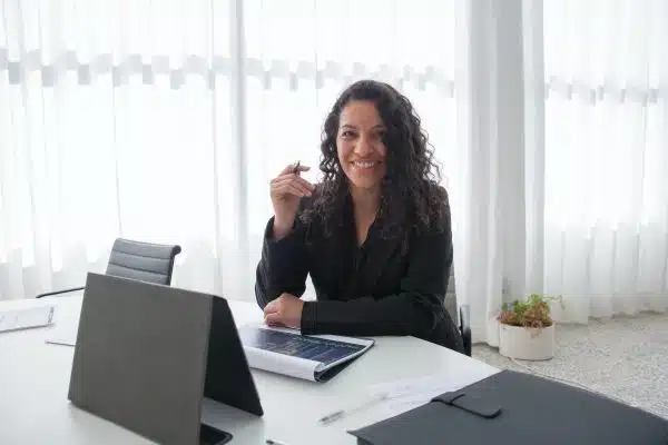 A smiling woman going through a presentation at her desk