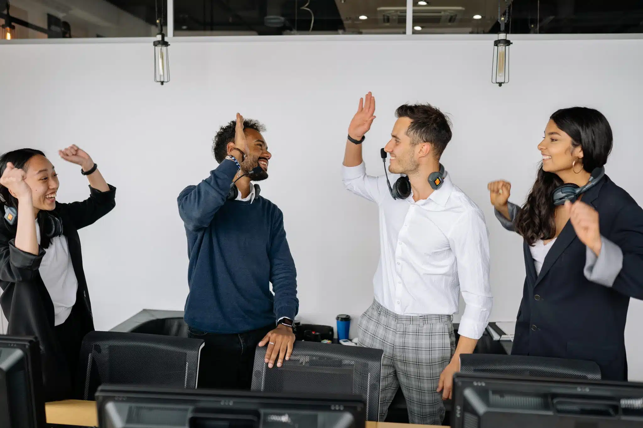 4 employees giving high fives